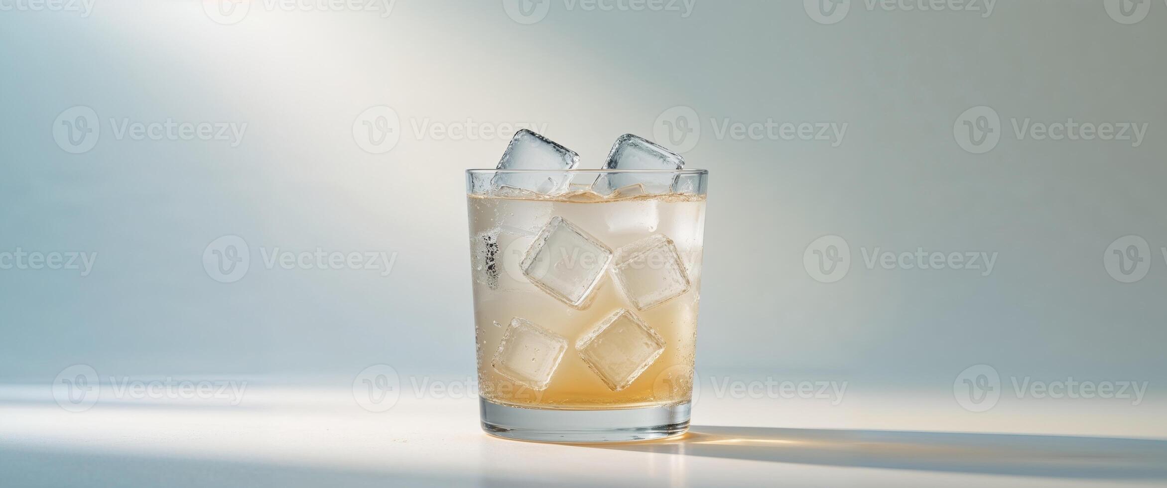 Refreshing Glass of Iced Beverage with Ice Cubes and Shadow photo