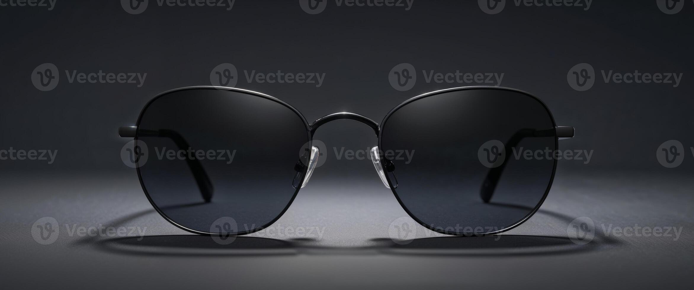Stylish black sunglasses on dark background. photo
