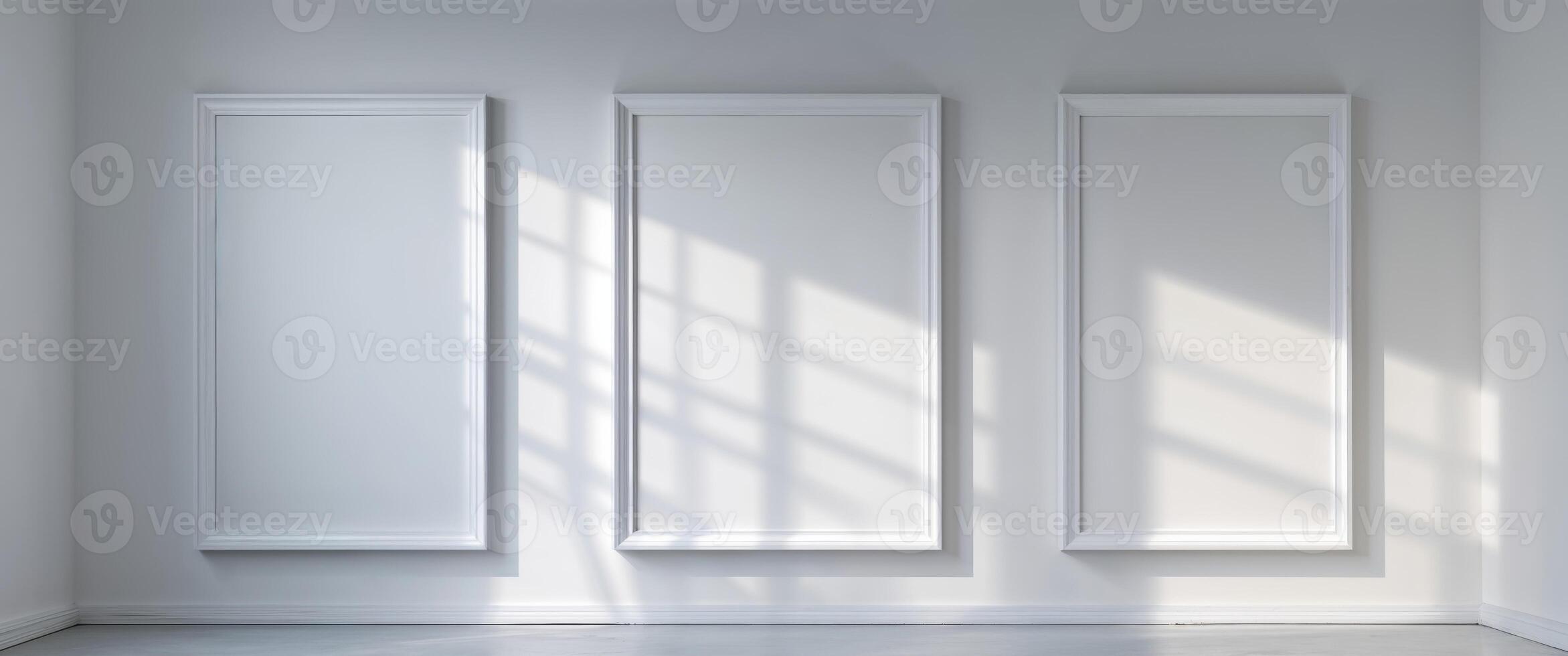 Three large blank white frames hanging on the wall in an art gallery ready for display. photo