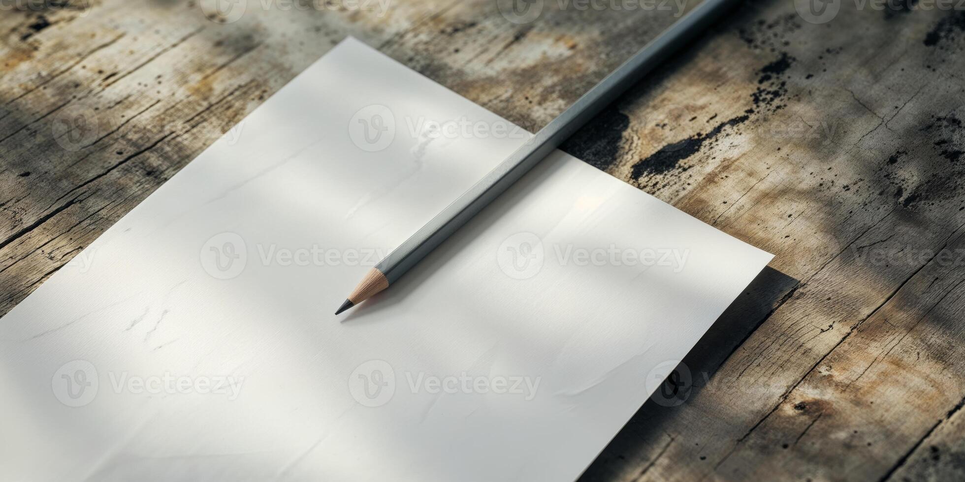 A white sheet of paper with a pencil on top photo