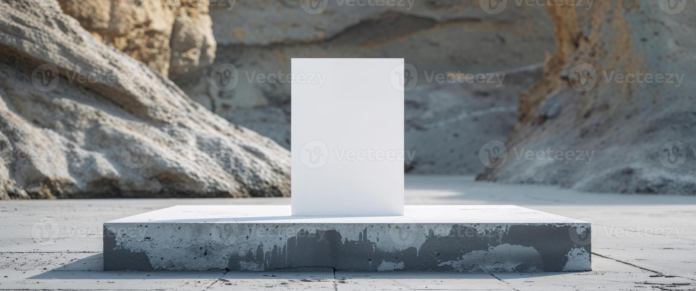 A white square on a concrete block in front of a cliff photo