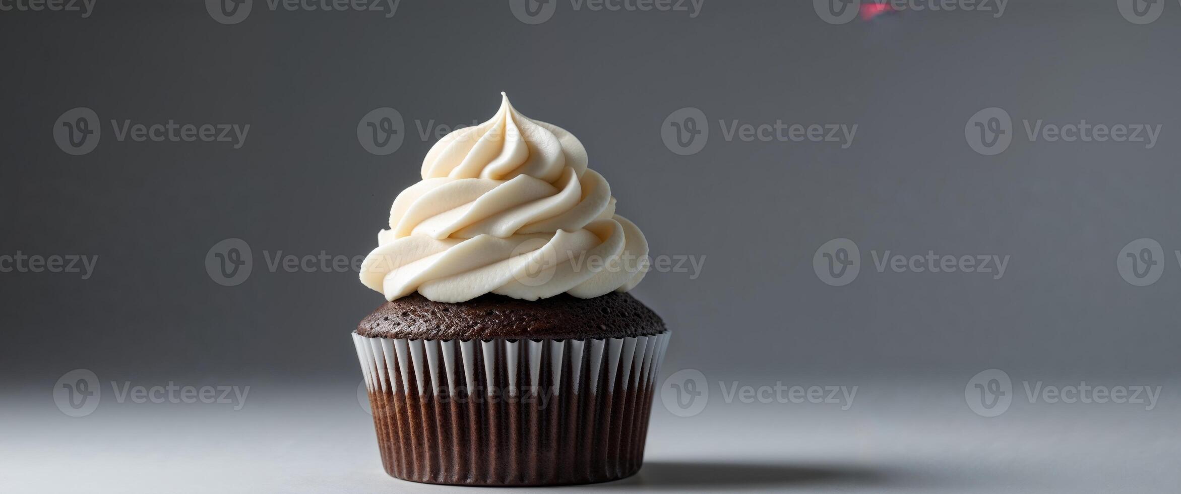 Chocolate Cupcake with White Frosting on Dark Background. photo