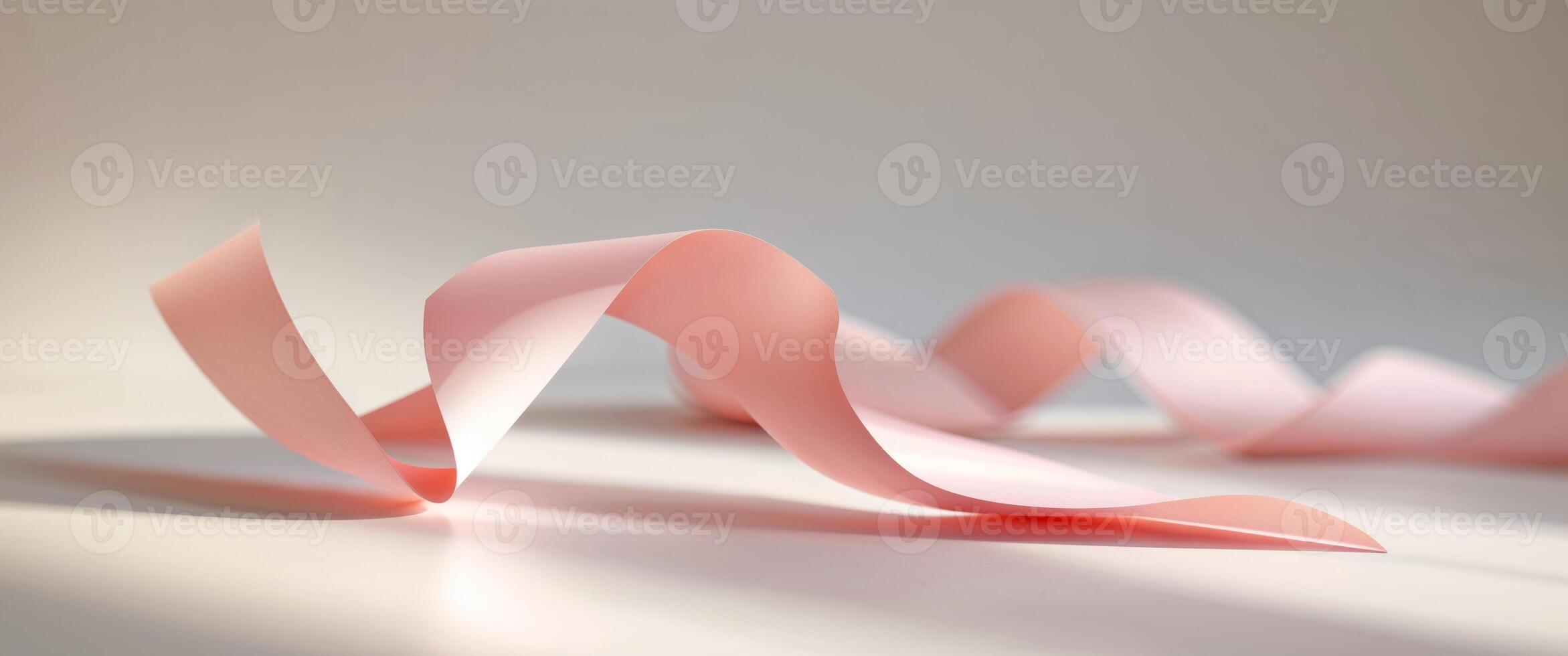 Abstract graphic of pink paper ribbon with folded design casting subtle shadow on neutral backdrop. photo