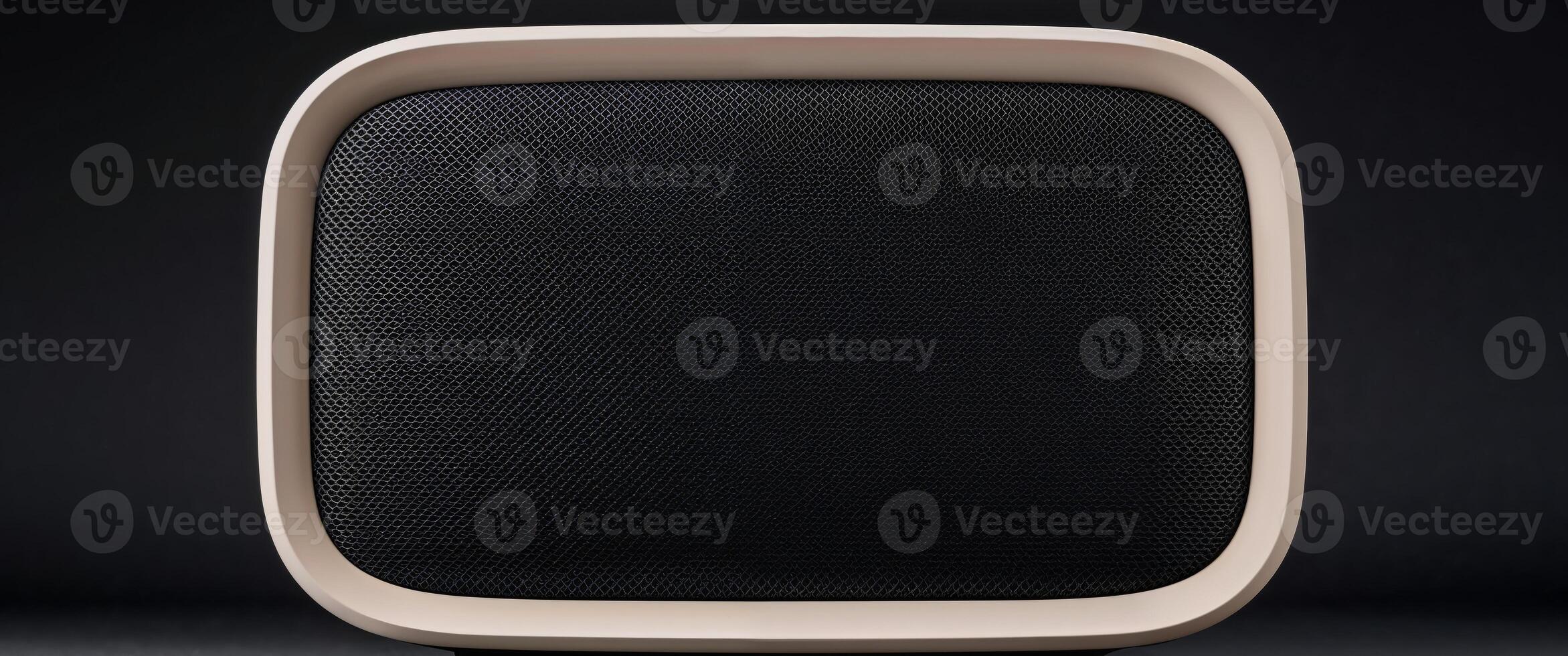 A close up shot of a modern speaker with a black mesh front and a beige frame on a black background photo