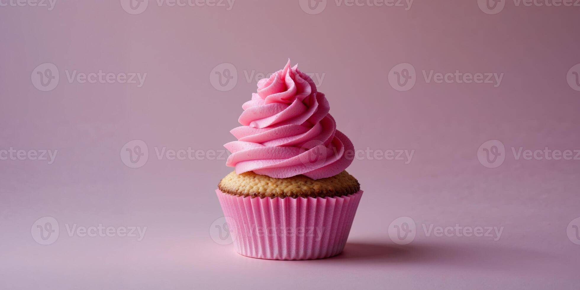 A single cupcake with pink frosting in a pink wrapper on a pink background in a studio shot. photo