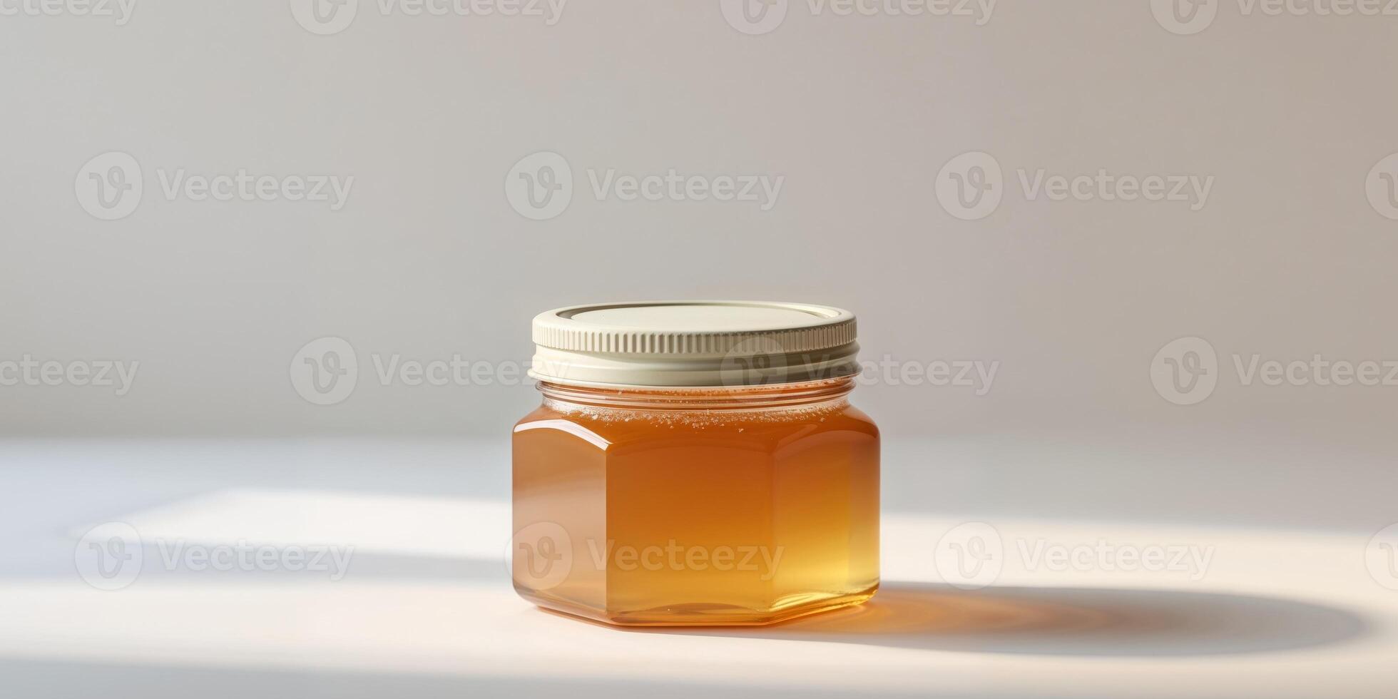 A jar of honey on a table with a light photo
