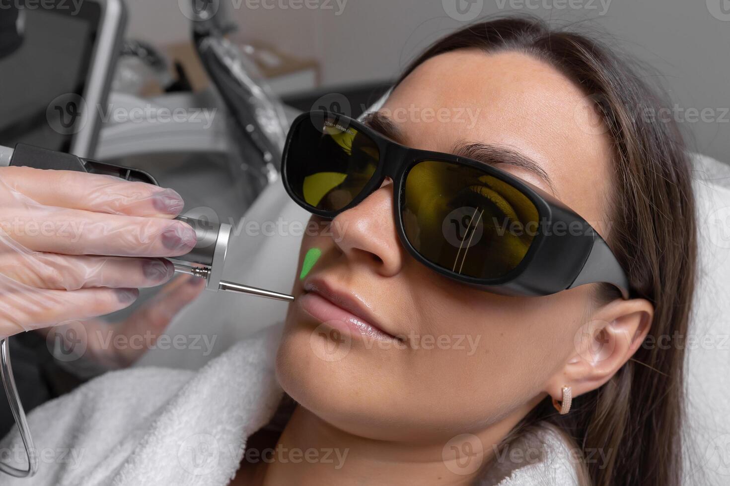 Woman receiving laser treatment in a modern clinic setting photo