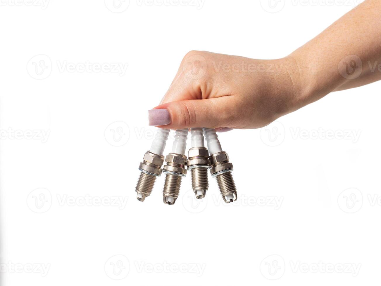 Car spark plugs in a girl's hand on a white background, isolate. Close-up photo