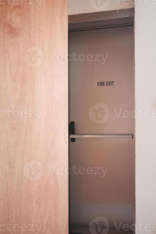 Fire exit door partially opened in a modern building hallway photo