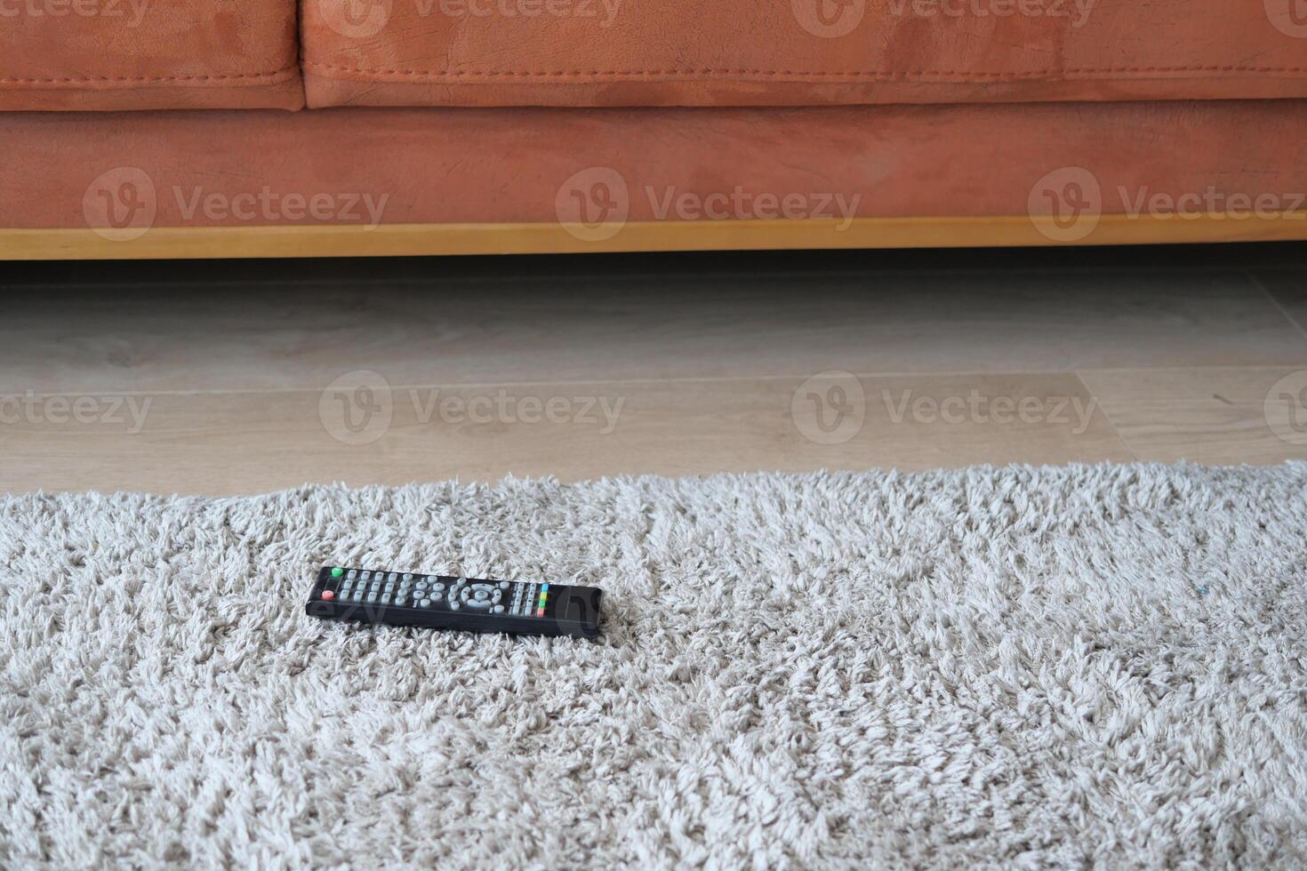 Remote control lies on fluffy rug in cozy living room photo