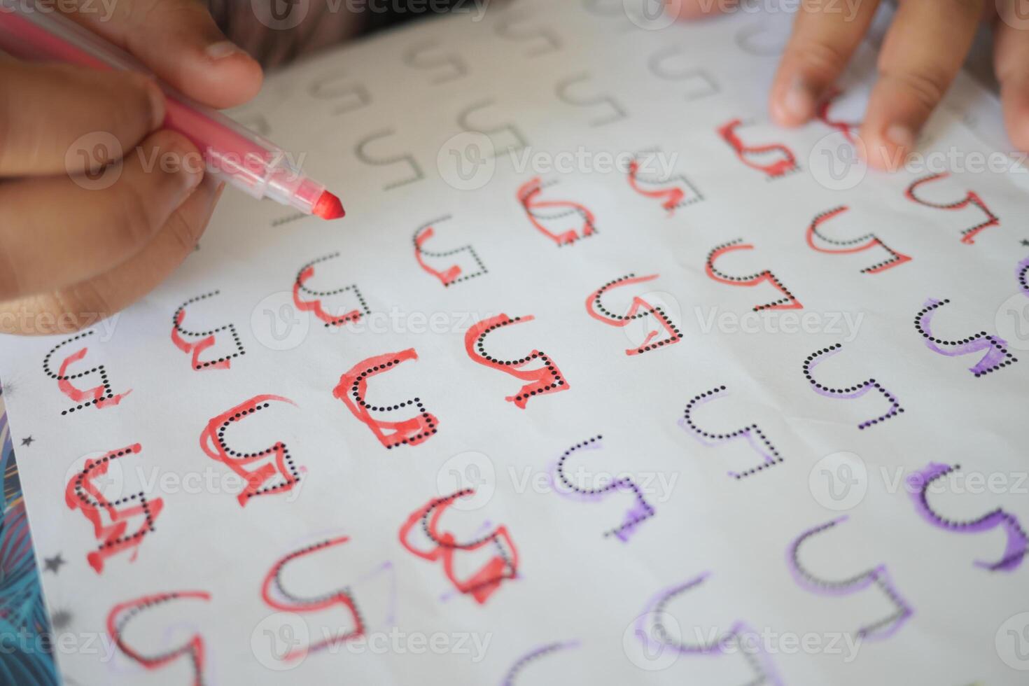 Learning to write letters with colored markers in a classroom setting photo