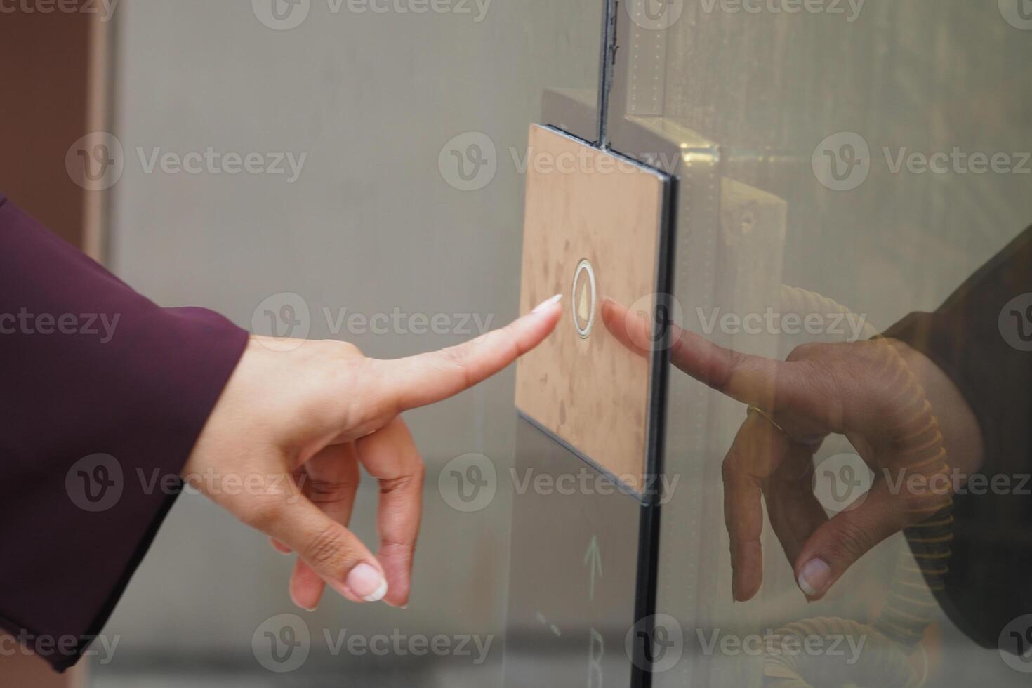 Person pressing elevator button in a modern building lobby photo