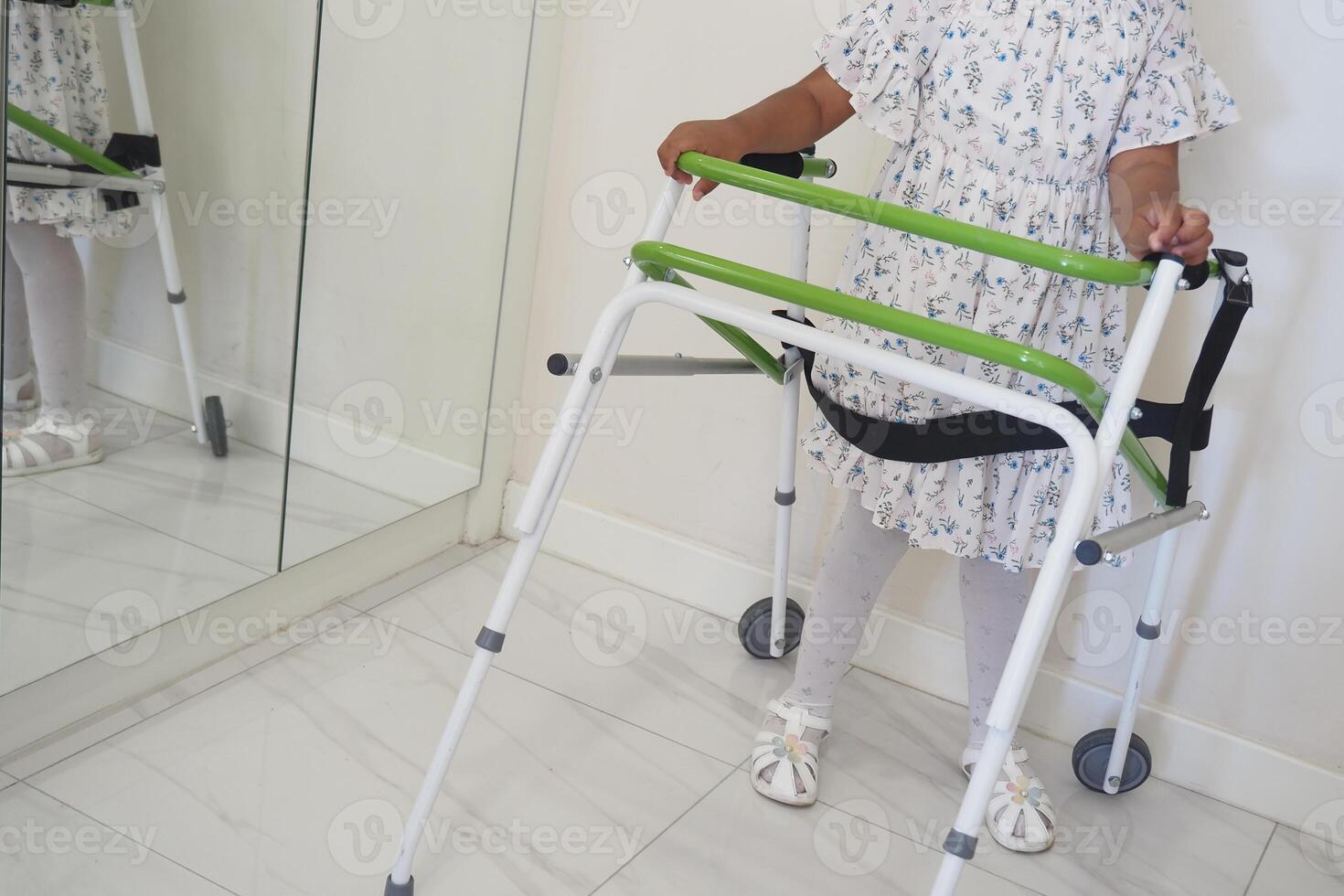 Child using a walker in a bright indoor space photo