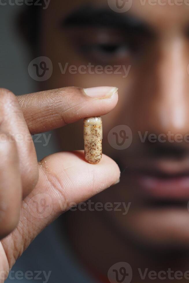 Holding a capsule with curiosity in a close-up photo