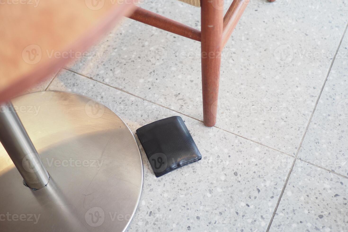 Wallet found on the floor near a table in a casual setting photo