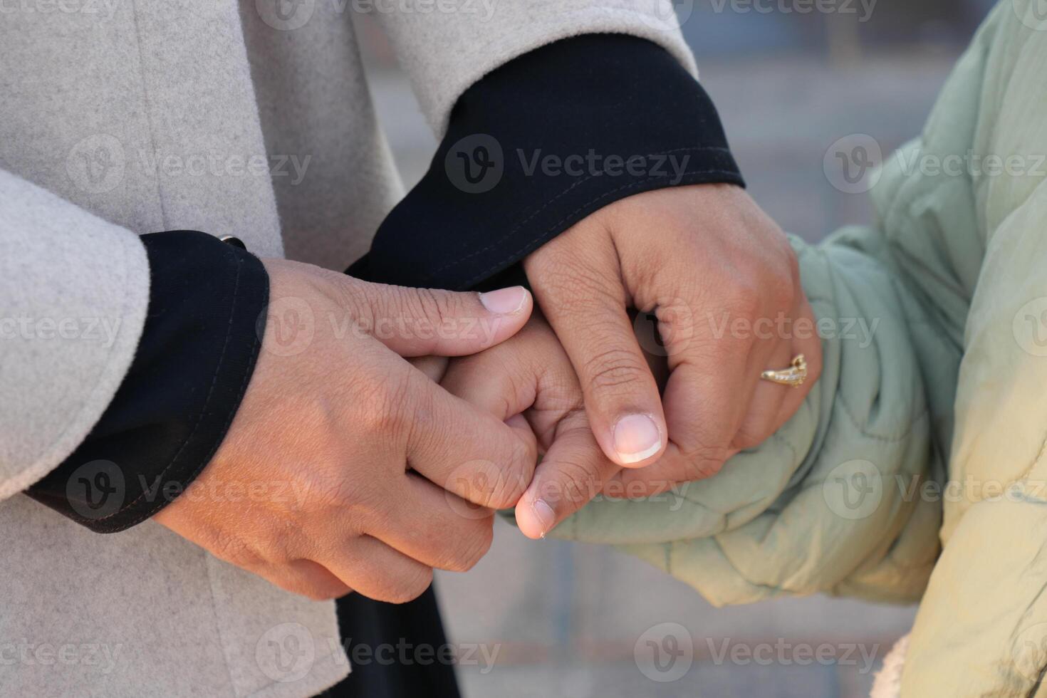 mother hold hands her child in a warm gesture of affection photo
