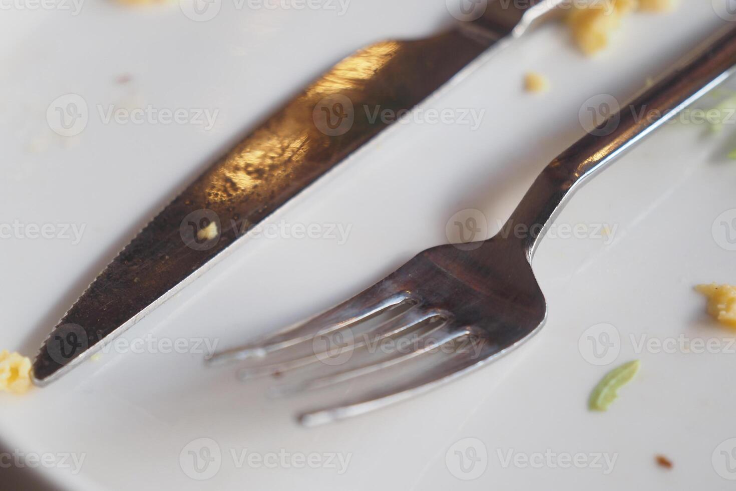Dining utensils on a plate after a meal in a restaurant setting photo