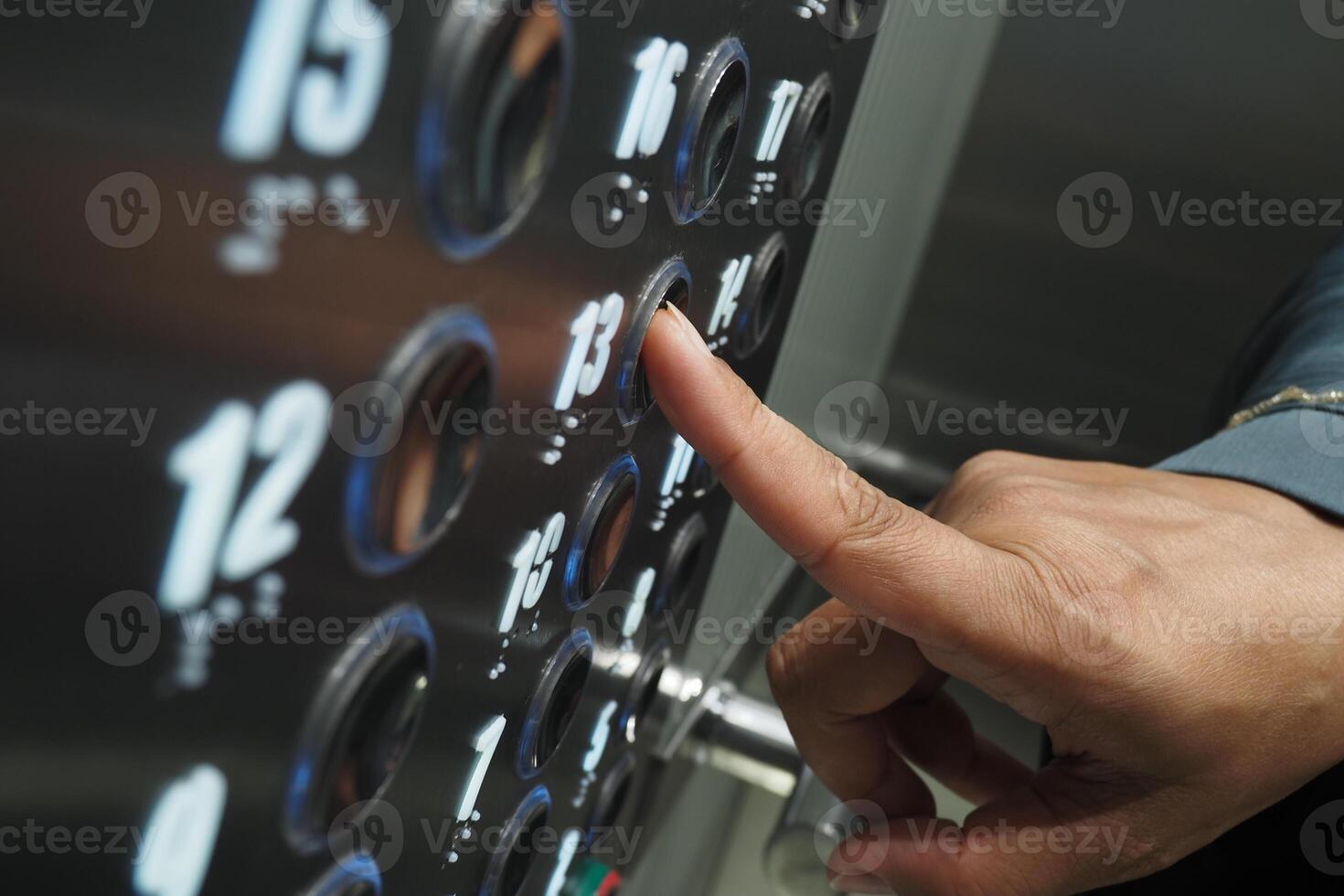 Close-up of a hand pressing elevator button on the floor panel photo