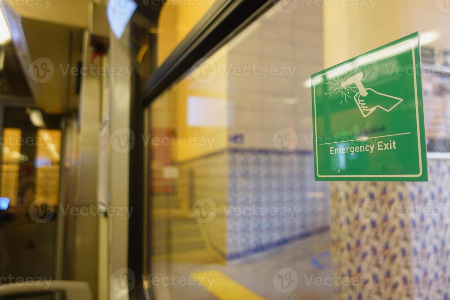 Emergency exit sign visible in public transport station interior photo