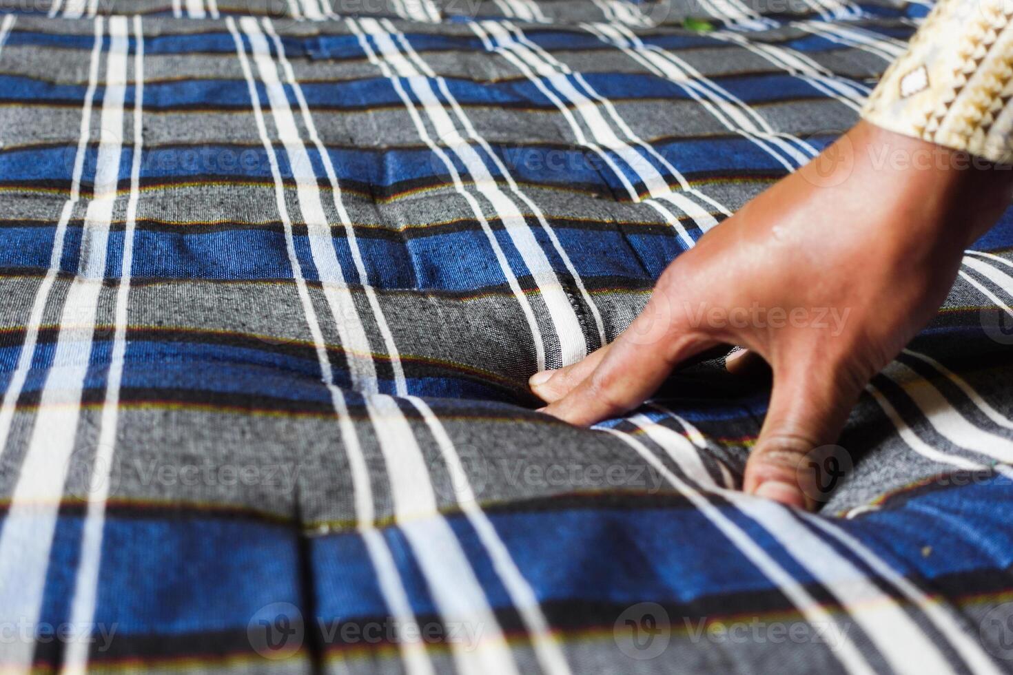 Hand pressing fabric to create texture on a blue striped pattern photo