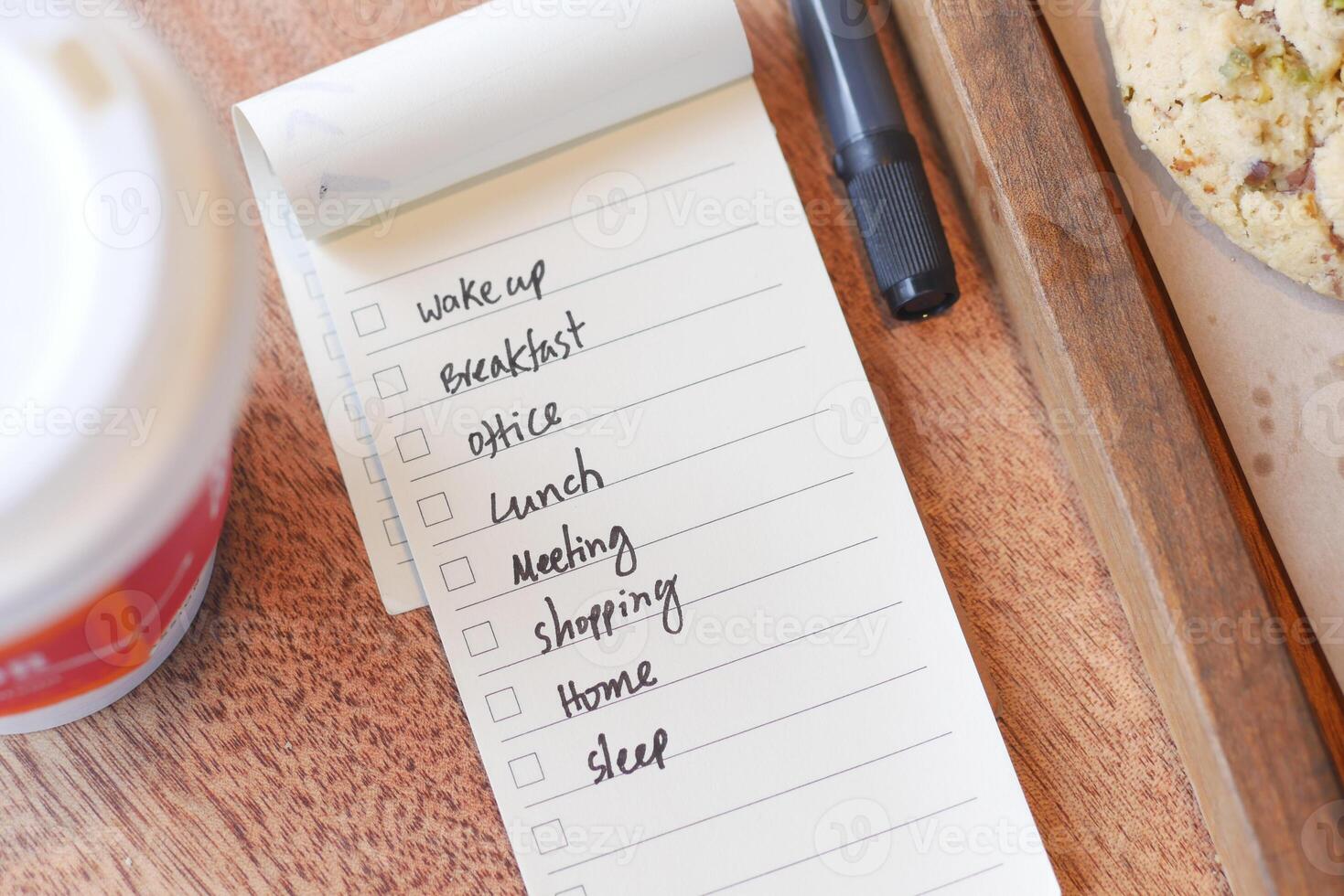 Daily to-do list with breakfast items and coffee on wooden table photo