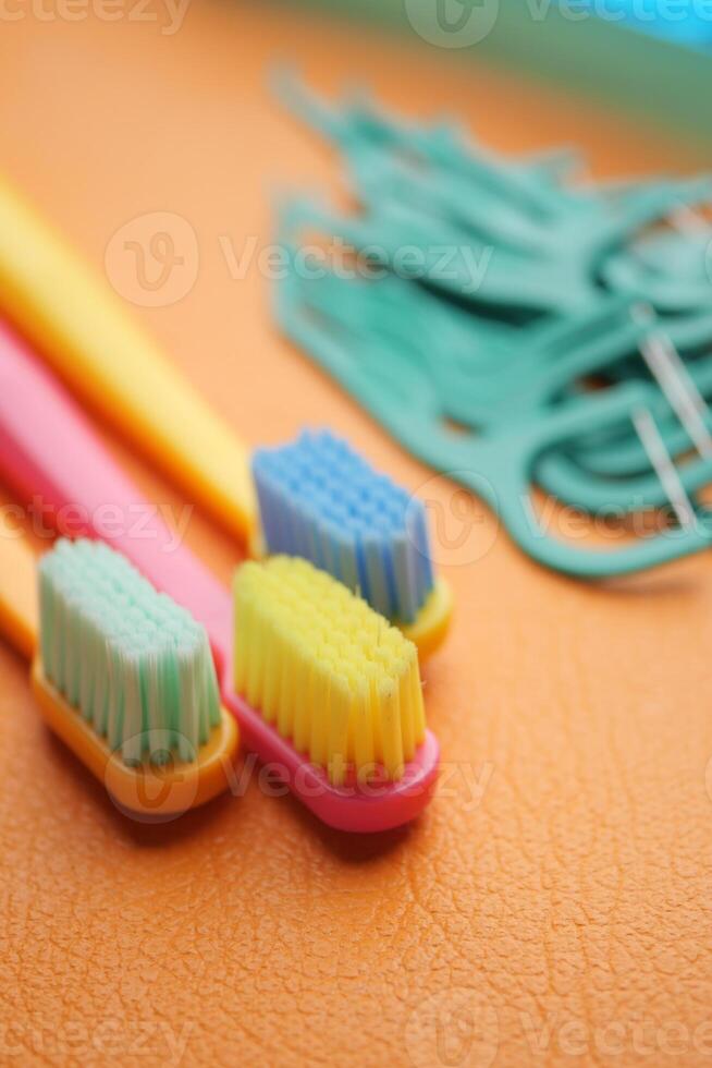 Colorful toothbrushes and dental floss tools on a bright surface photo