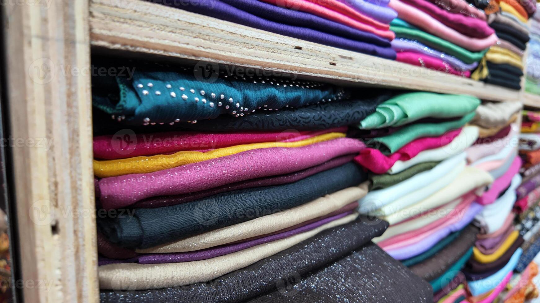 Colorful fabric rolls displayed in a textile shop in a busy market photo
