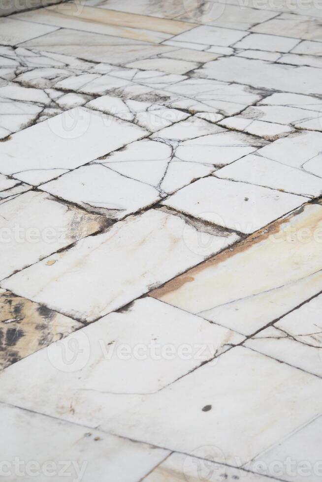 Old cracked marble flooring with distinct patterns in a quiet setting photo