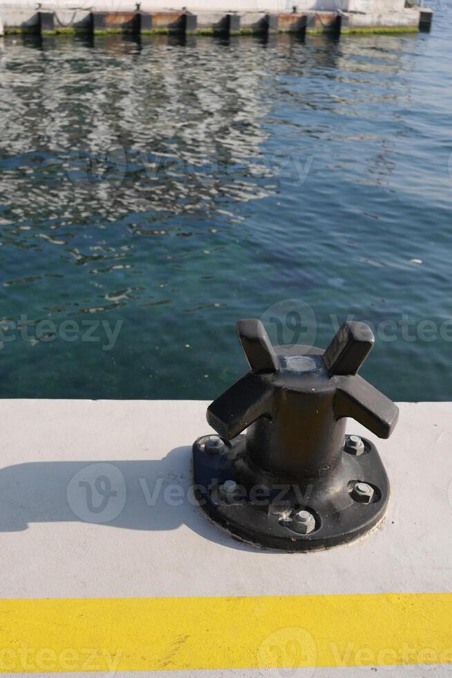 Docking fixture along the harbor with calm waters reflecting light photo
