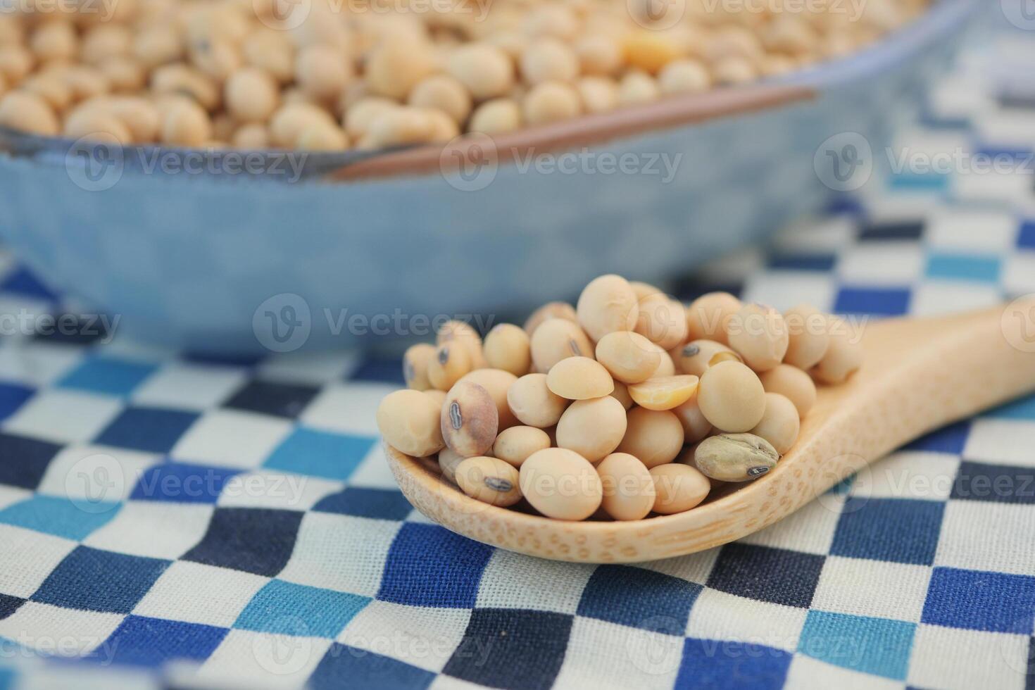 Soybeans displayed in a wooden spoon on a checked tablecloth photo