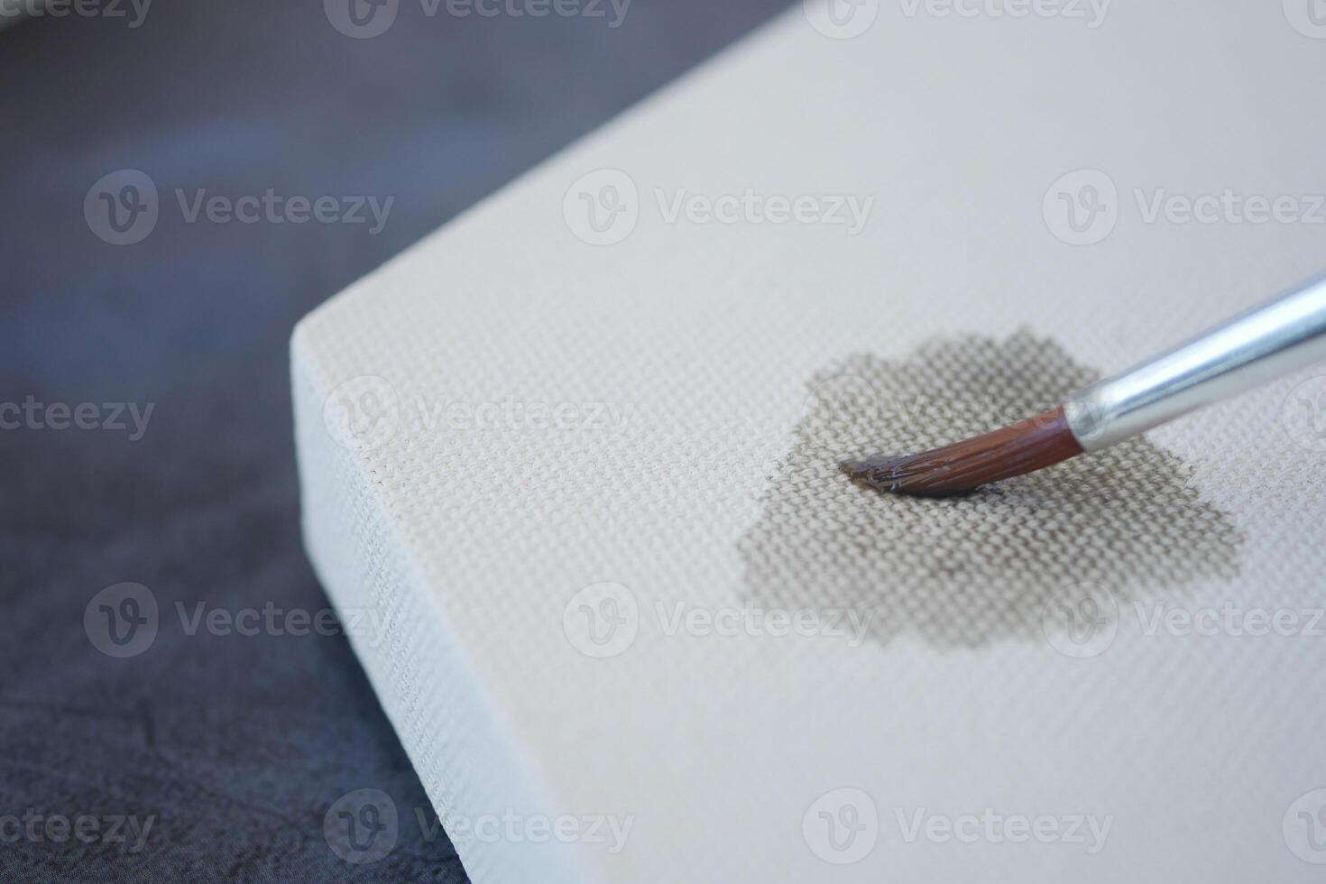 Artistic process on blank canvas with a brush applying paint photo