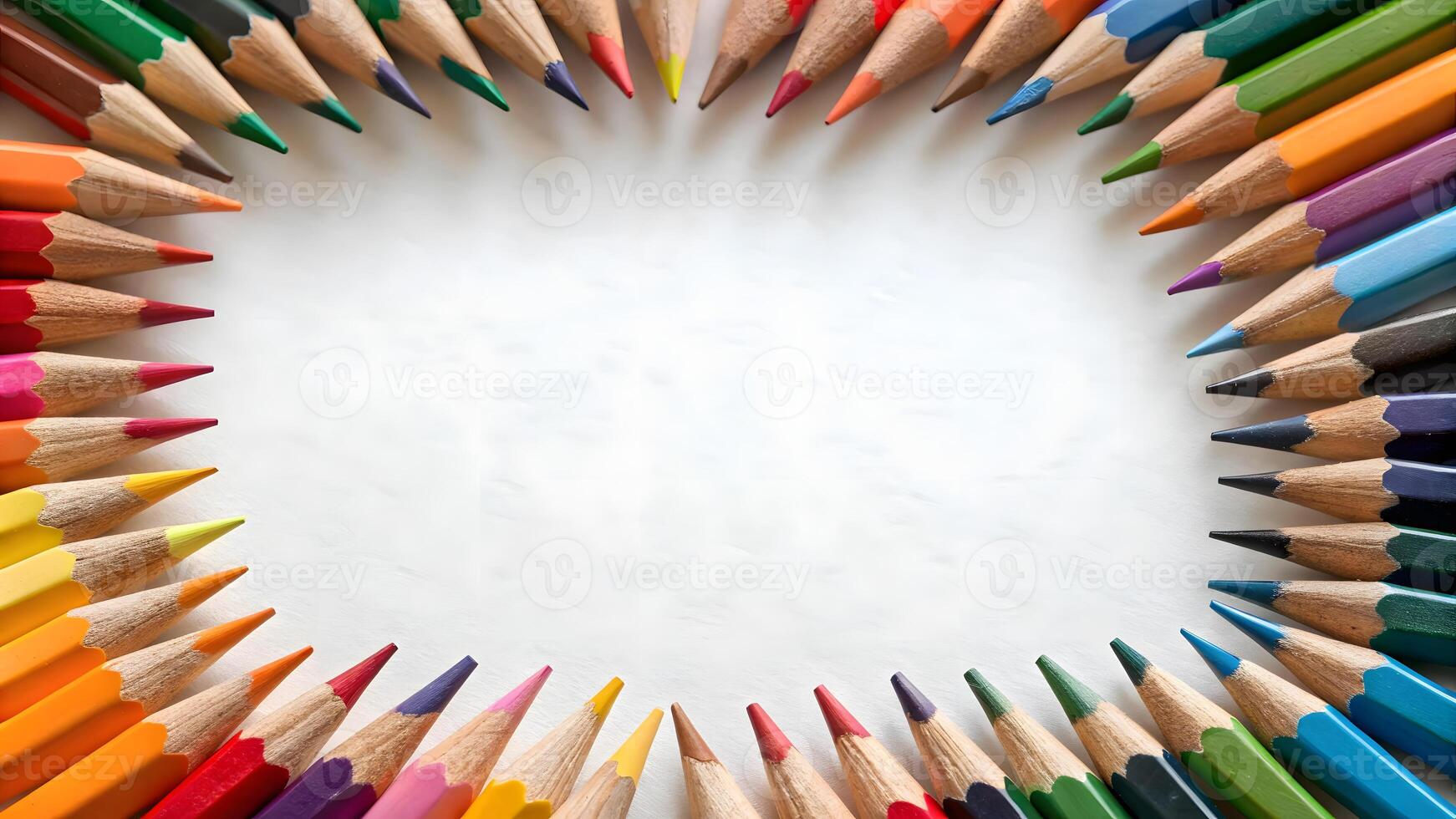 Colorful pencils arranged in a circular border around a blank space photo