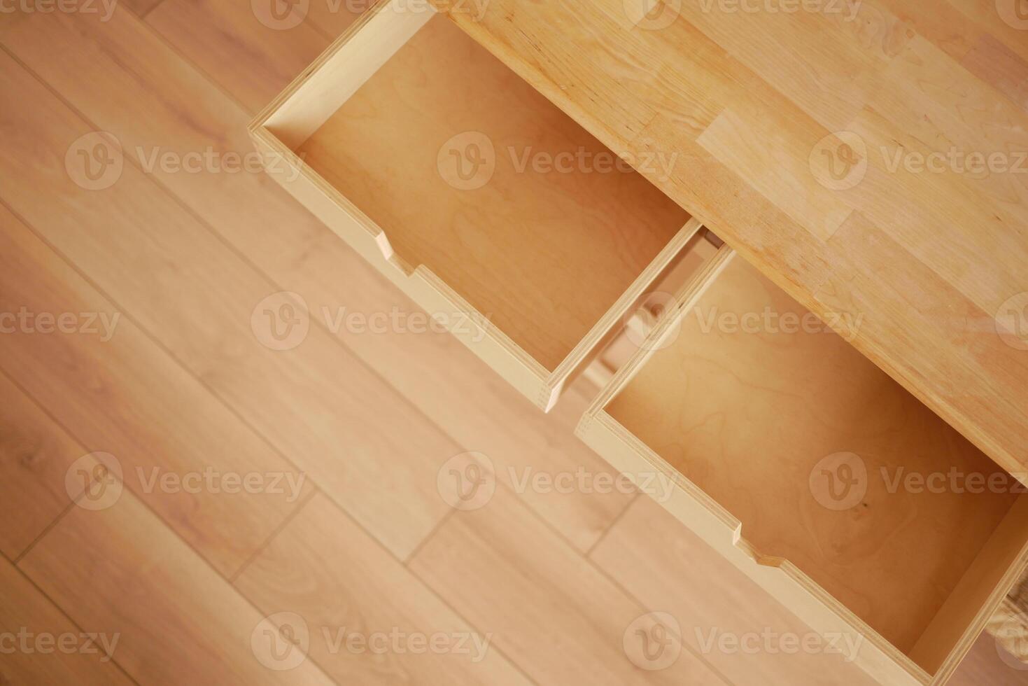 Open wooden drawers in a minimalist room with light flooring photo