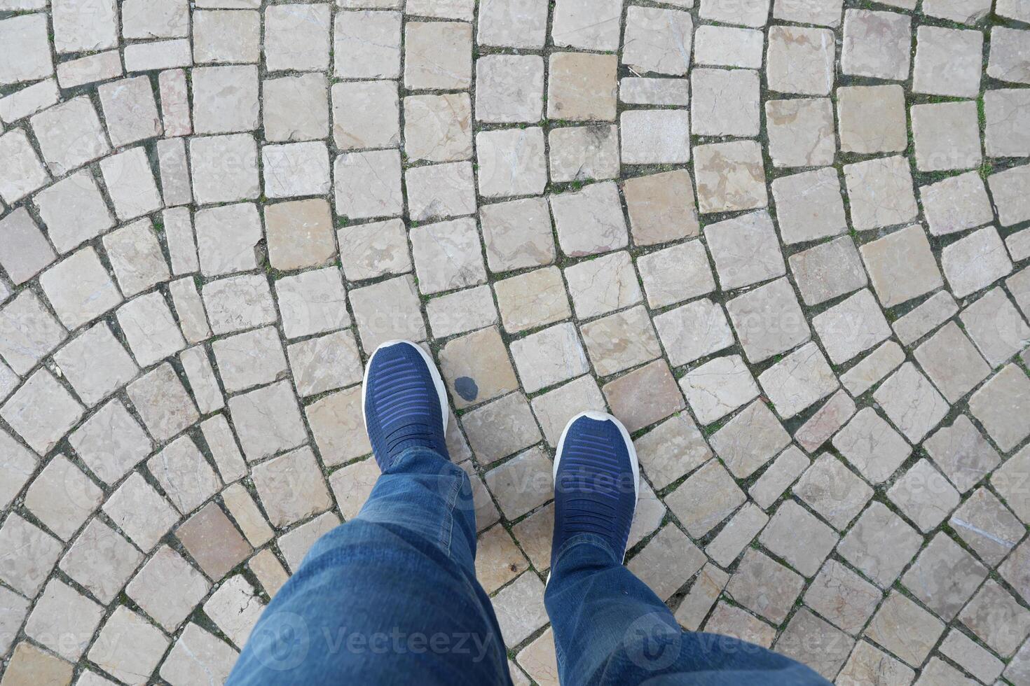 Walking on a cobblestone path in casual footwear photo