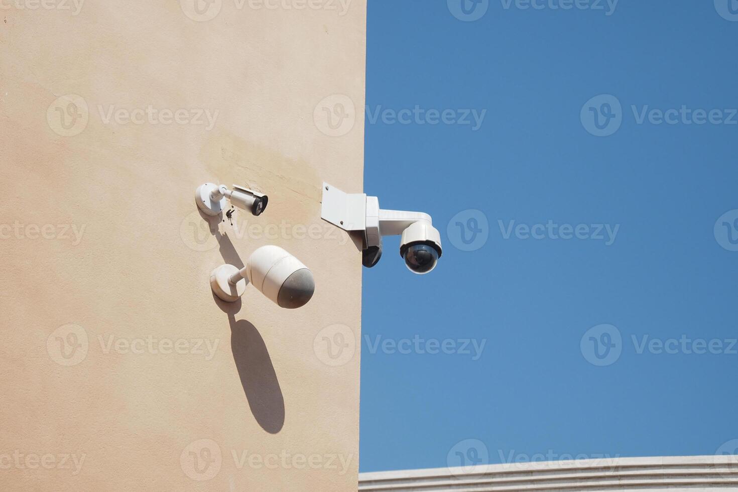 Security cameras mounted on a building under clear blue sky photo