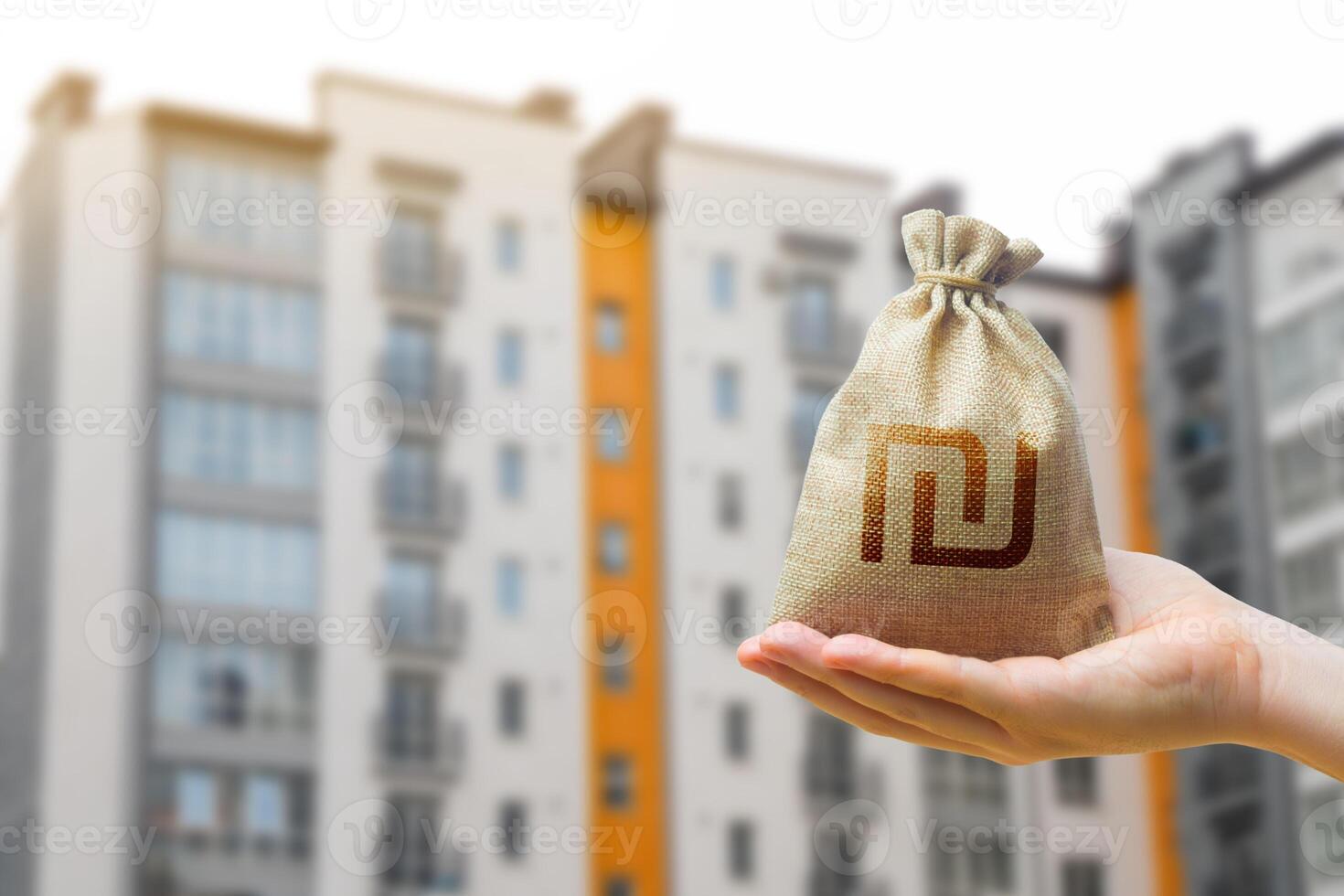 Israeli shekel bag against the background of modern high-rise buildings. Investing in the purchase of real estate. Affordable housing and mortgage rates. Renting apartments and houses. Blurred photo