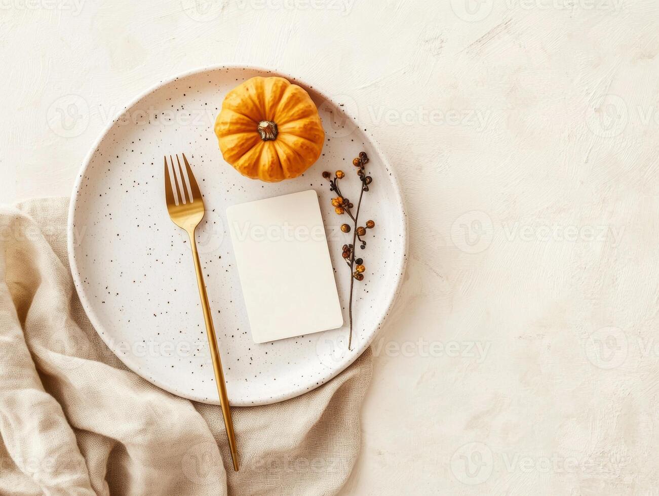 Autumn table setting with mini pumpkin and golden cutlery on white plate photo