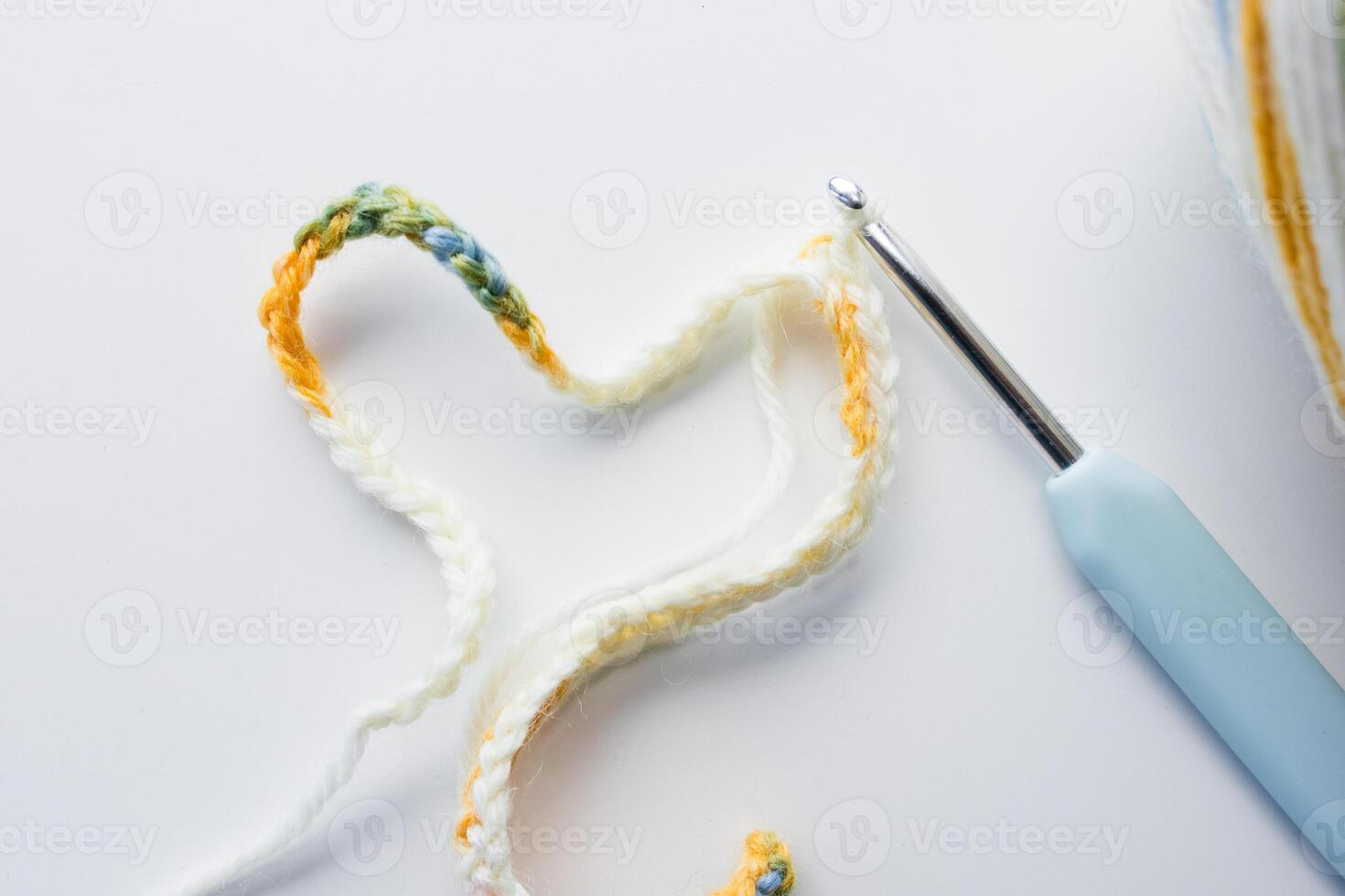 Colorful crochet yarn and hook on white background photo