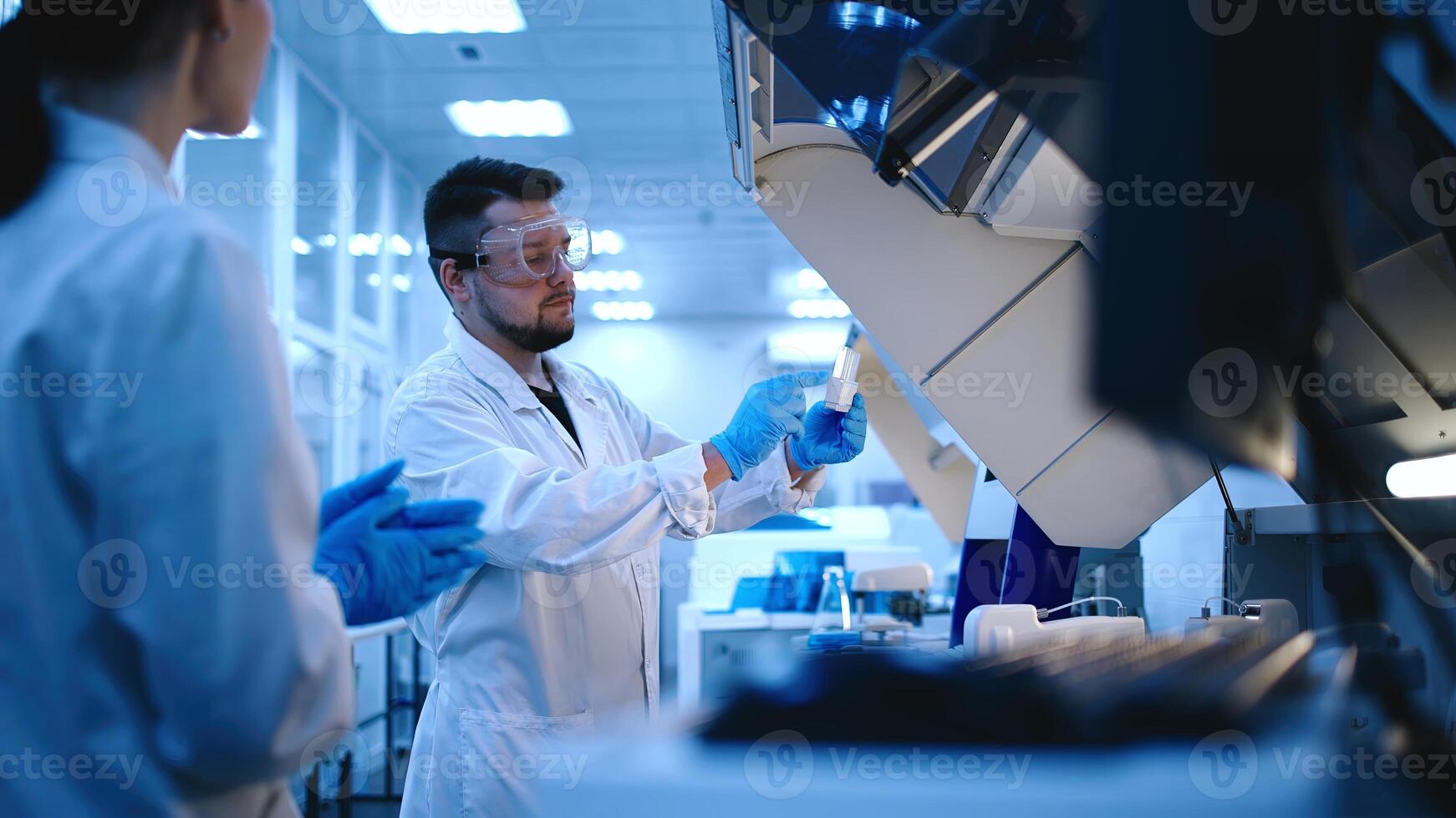 Team of Medical Research Scientists Work on a New Generation Disease Cure. They use Microscope, Test Tubes, Micropipette and Writing Down Analysis Results. Laboratory Looks Busy, Blue and Modern photo