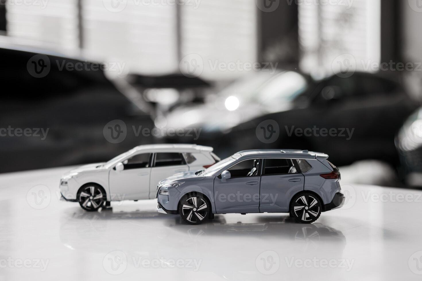 Two small car model toys is placed on a table against blurred auto background. Premium car buying experience that combines expert guidance with high-class service in an elegant setting. Banner, ads photo
