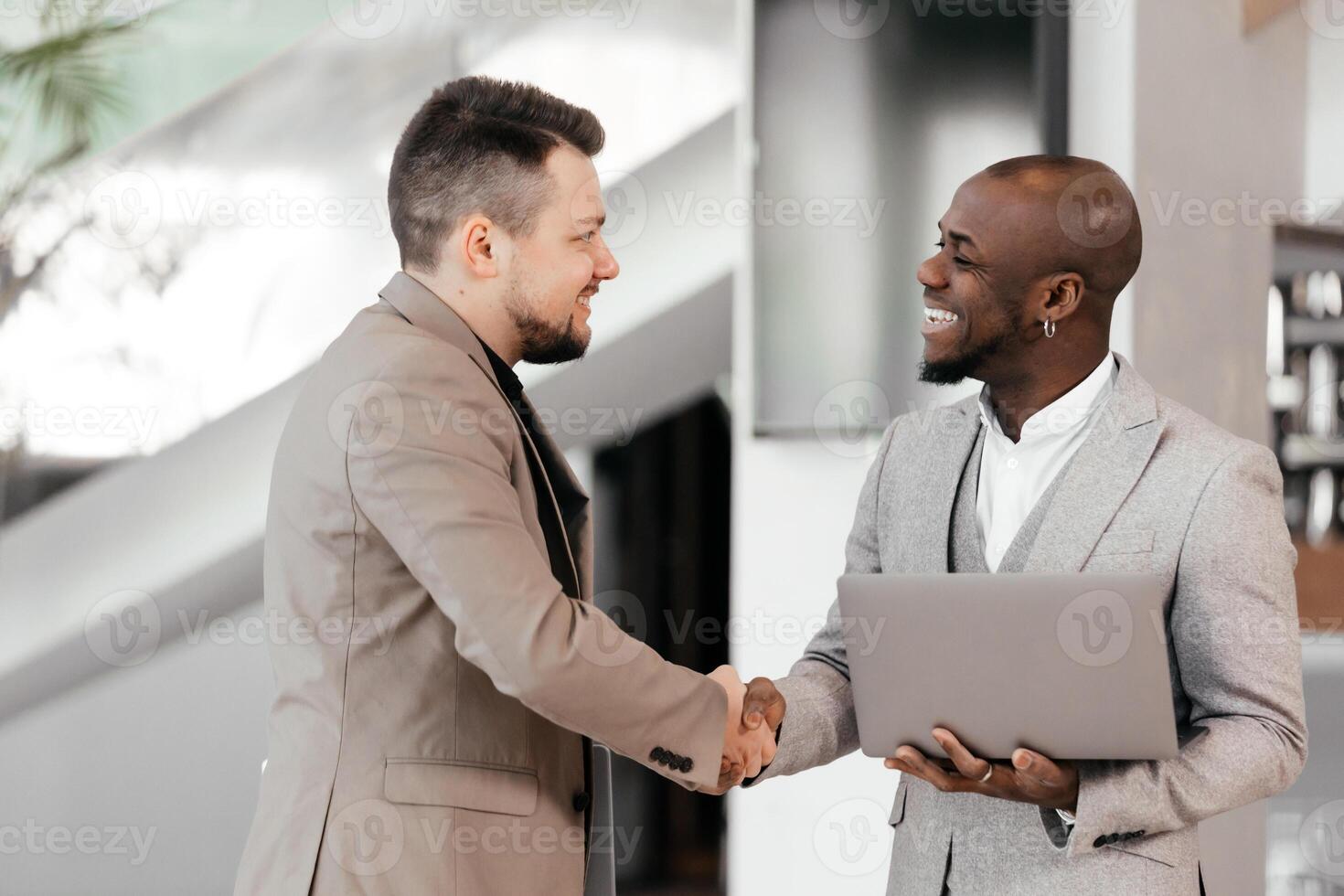 African Manager, business men in meeting with laptop, coaching or learning in creative startup. Team, leader and discussion for brainstorming ideas, project update for event planning. Handshake, deal photo