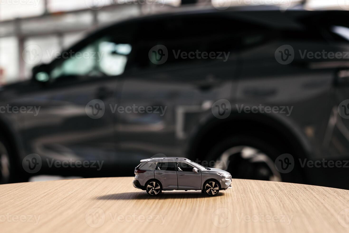 Small car model toy is placed on a table against blurred auto background. Premium car buying experience that combines expert guidance with high-class service in an elegant setting. Copy space, banner photo