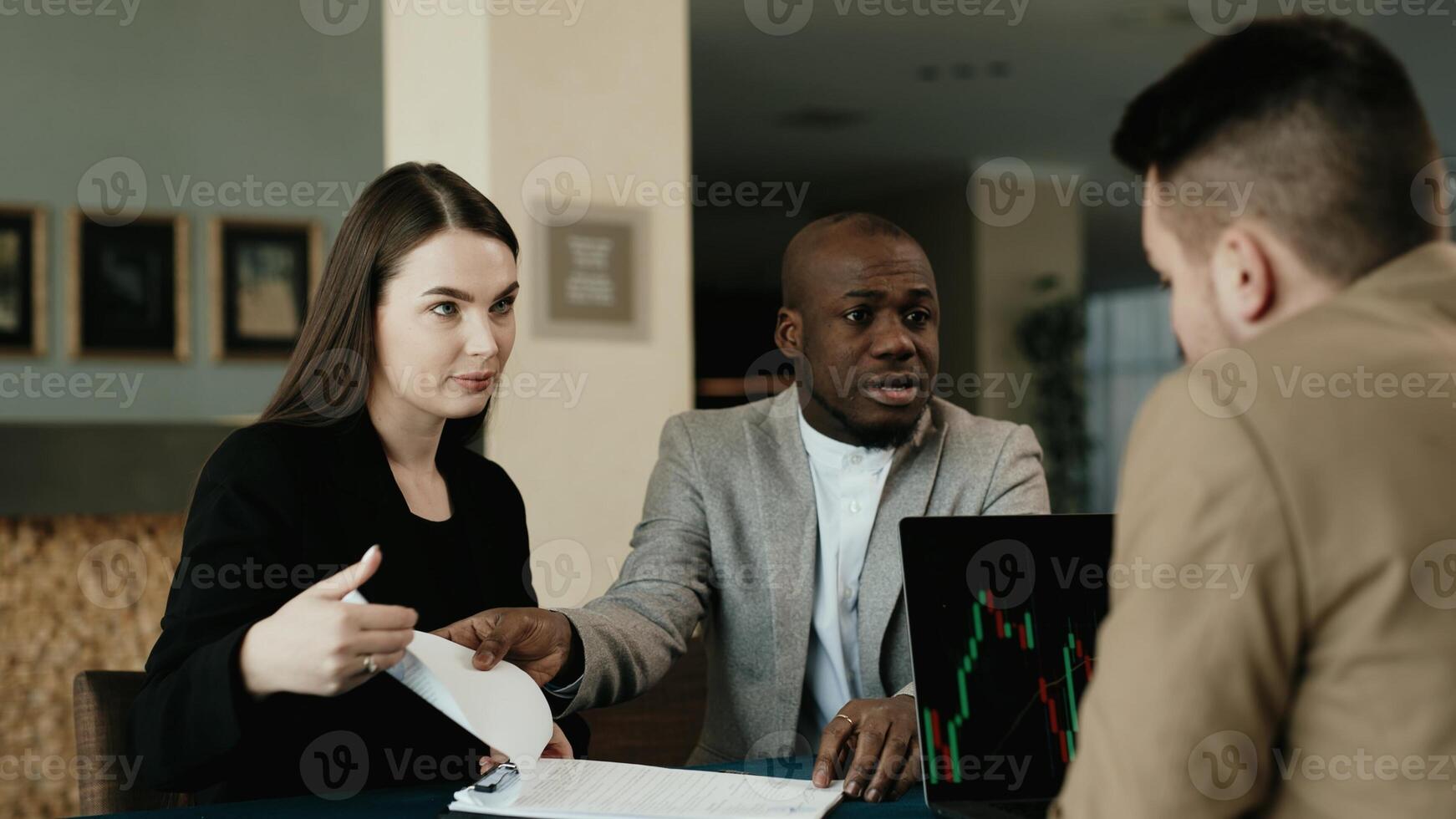 Three multiracial professionals man and woman business leaders partners checking document reading financial report talking working together on laptop computer in office at corporate meeting photo