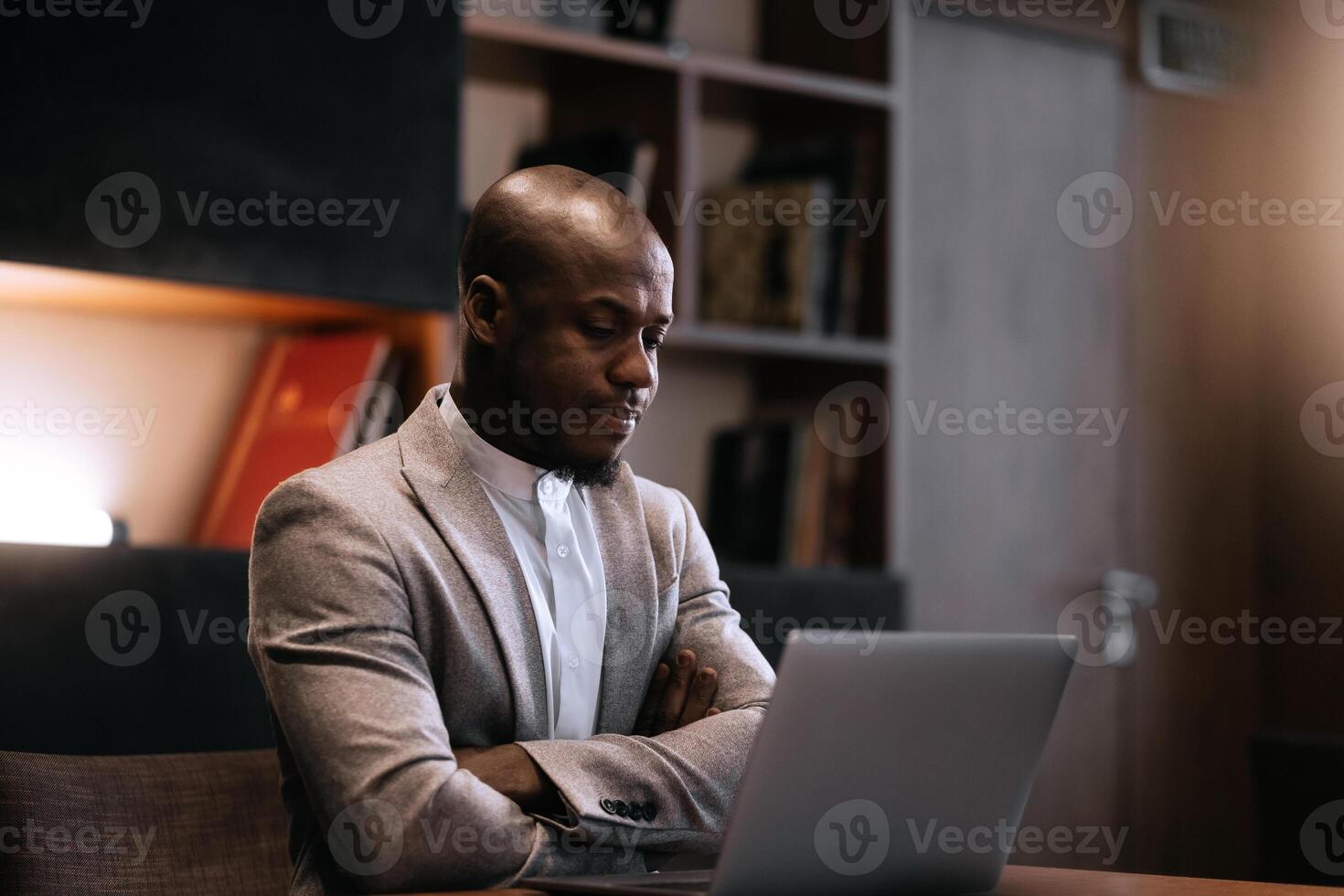 Stress, burnout and business black man at night working on project, report and strategy deadline. Headache, mental health and male in dark office frustrated, tired and work problem on laptop photo