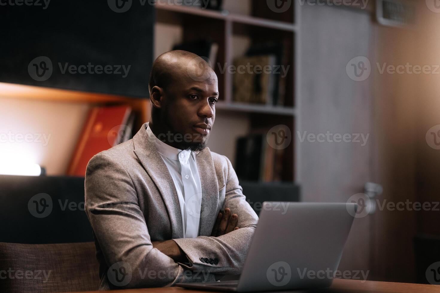 Stress, burnout and business black man at night working on project, report and strategy deadline. Headache, mental health and male in dark office frustrated, tired and work problem on computer photo