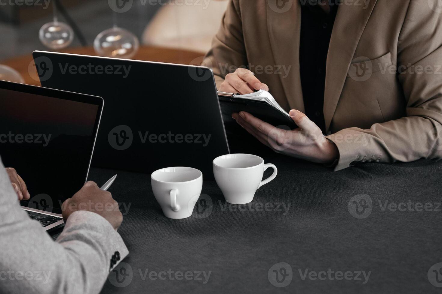 Close-up shot of business professionals discussing financial marketing data while sitting at a table with project documents during a business lunch. Copy space photo