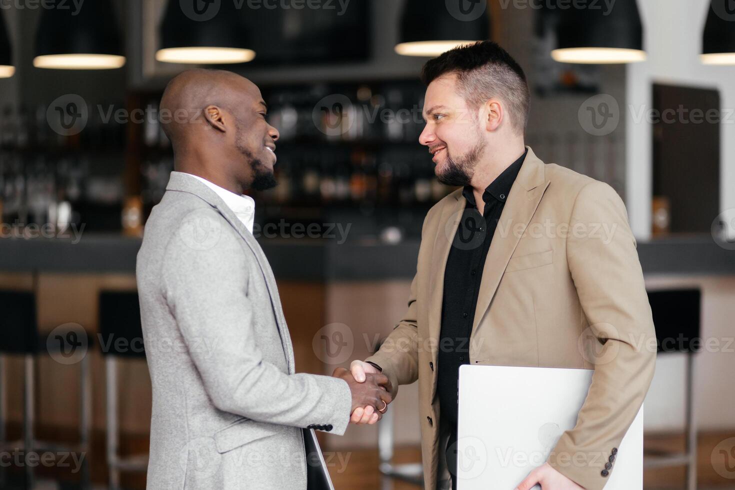 Black Manager two business men in meeting with laptop, coaching or learning in creative startup. Team, leader and discussion for brainstorming ideas, project update for event planning. Handshake, deal photo