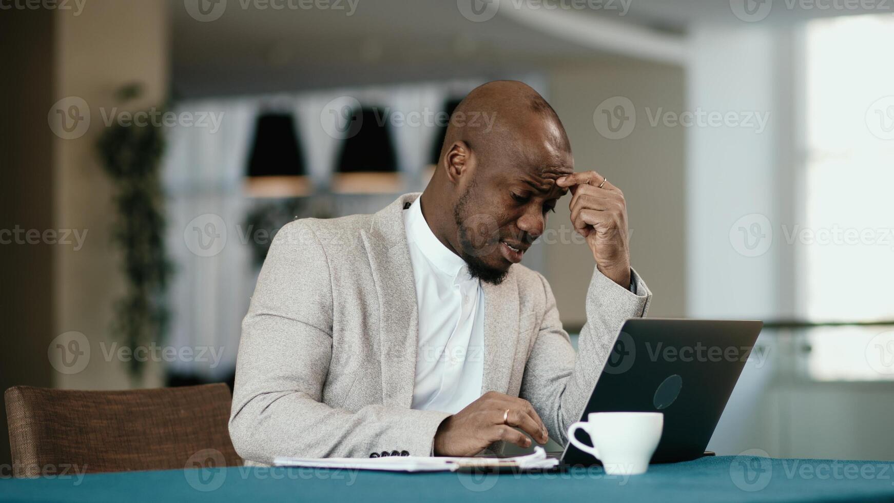 Tired African American businessman sleepy and bored from sitting at a desk for a long time and has office syndrome. Tired upset trader man of problem in business. Concept of stressful life, deadline photo