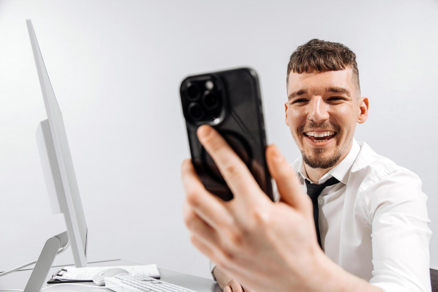 Close-up business man receives a positive message on his phone while working at his computer. The concept of financial income, transaction and successful business photo