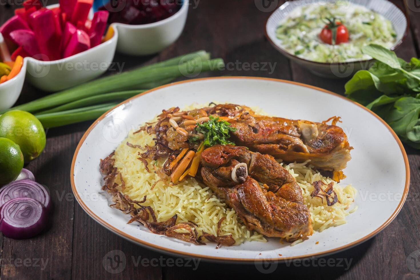 Mandi Rice with Meat served on a white plate features tender meat, aromatic rice, and various side dishes isolated on wooden table side view of a gourmet Arabian platter photo